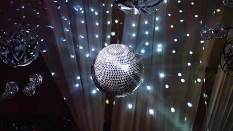 silver shining disco ball. mirror ball hanging from the ceiling and spinning against beautiful lights. entertainment concept.