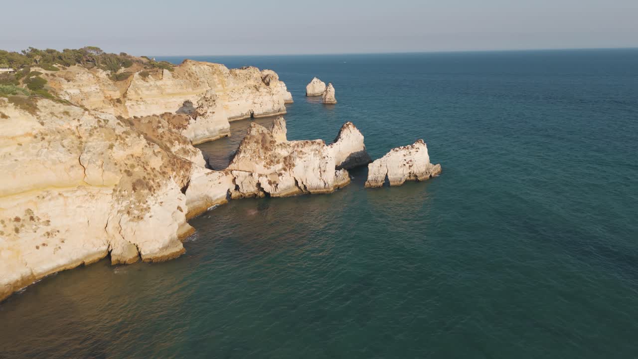 Golden cliffs and sea stacks along the coast of Alvor, Algarve Portugal