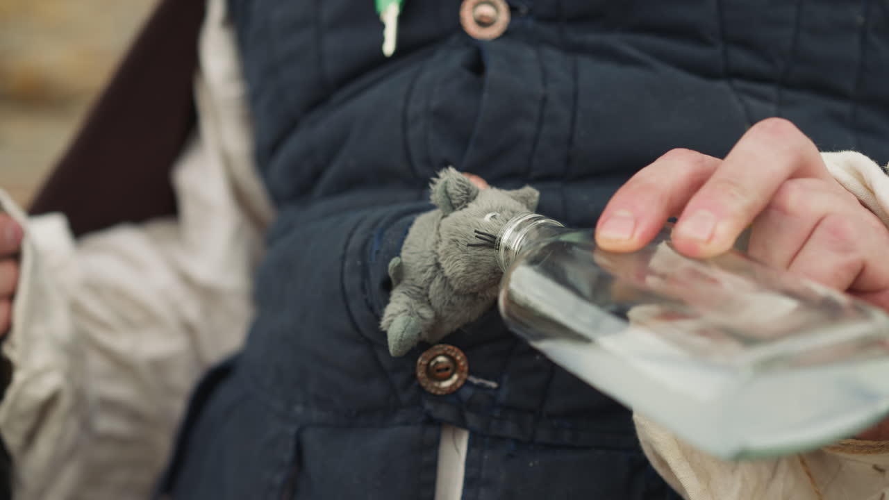남자 는 장난감  ⁇  에게 유리 병 에서 마법 의 음료 를 준다