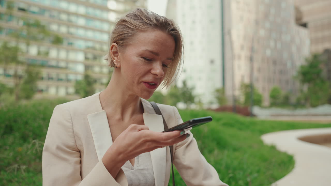 Businesswoman using phone in urban park
