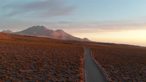 toma cinematográfica aérea de un camino de tierra al atardecer en el desierto de atacama, chile, sudamérica