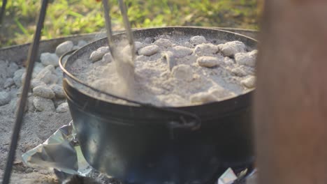 Checking-up-on-food-cooking-in-a-dutch-oven