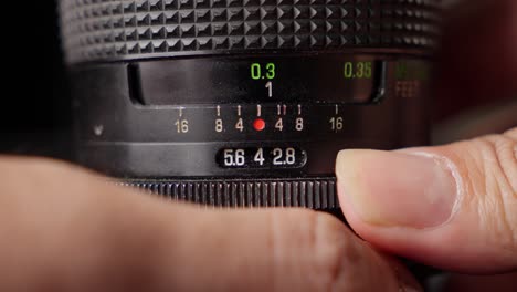 professional photographer adjusting lens aperture stop. close-up shot