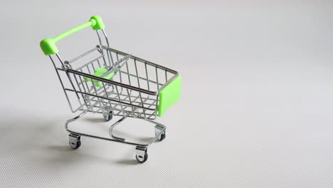 carrito de compras en miniatura de color verde en el supermercado de juguetes metálicos vacíos