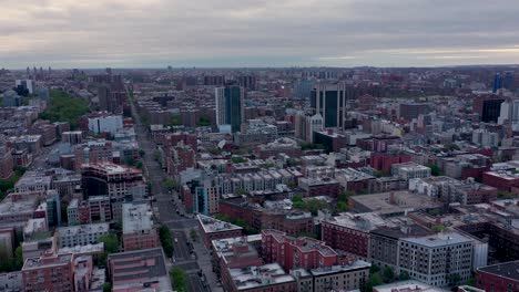 wide aerial view over harlem new york city tilts down to empty streets in the early morning