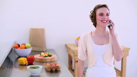 Pretty-model-standing-in-kitchen-talking-on-the-phone