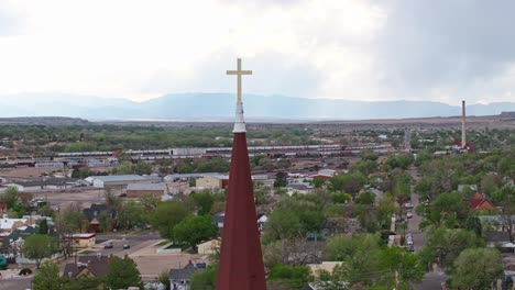 dron krąży wokół złotego krzyża na szczycie kościoła świętego serca w pueblo colorado.