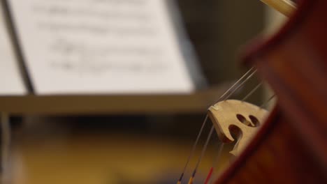 close-up of a brown cello's details, featuring a french bow gracefully laid upon it