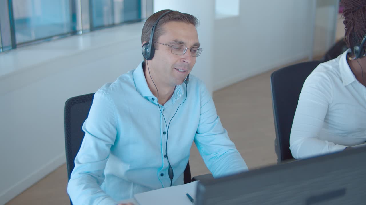 consultor masculino positivo en auriculares tomando llamada