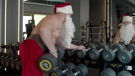 Papá-Noel-Haciendo-Ejercicios-Con-Mancuernas-En-El-Gimnasio.-Entrenamiento-De-Deportista-En-Club-Deportivo