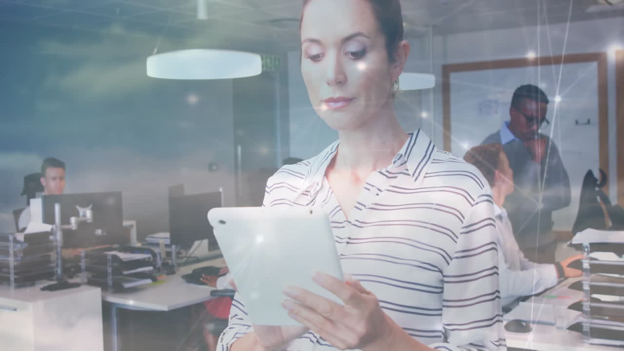 woman reviewing tablet in modern business office, with computers and animated data charts floating