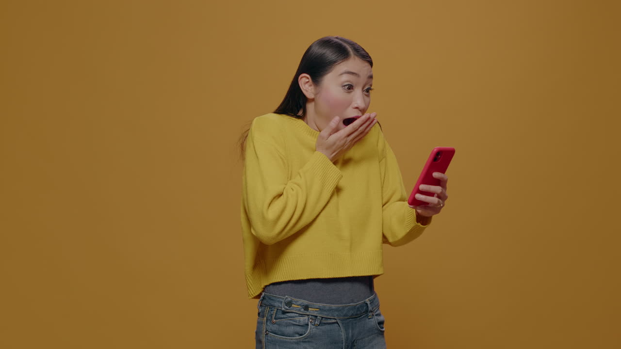 Amazed woman reading good news on smartphone