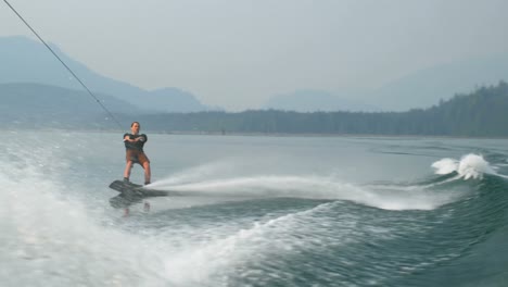 front view of caucasian young man doing tricks on wakeboard in the city river 4k