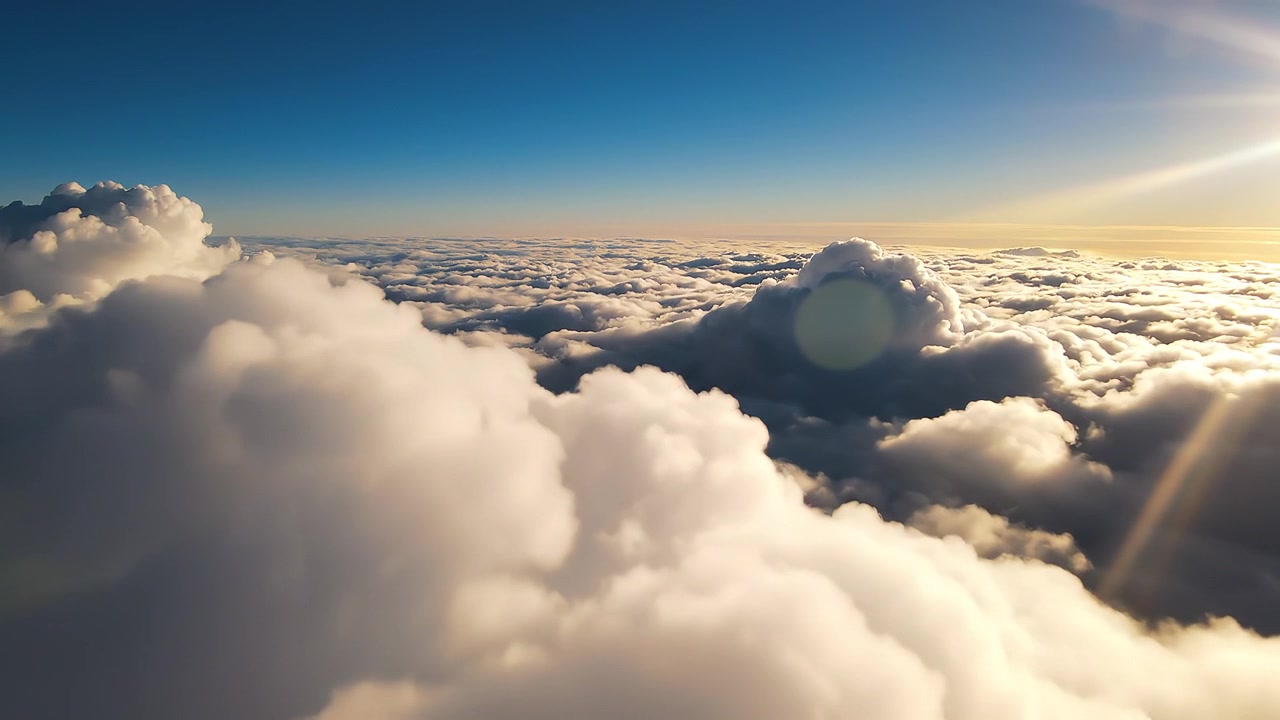 Vista aerea di soffici nuvole bianche durante un'alba dorata