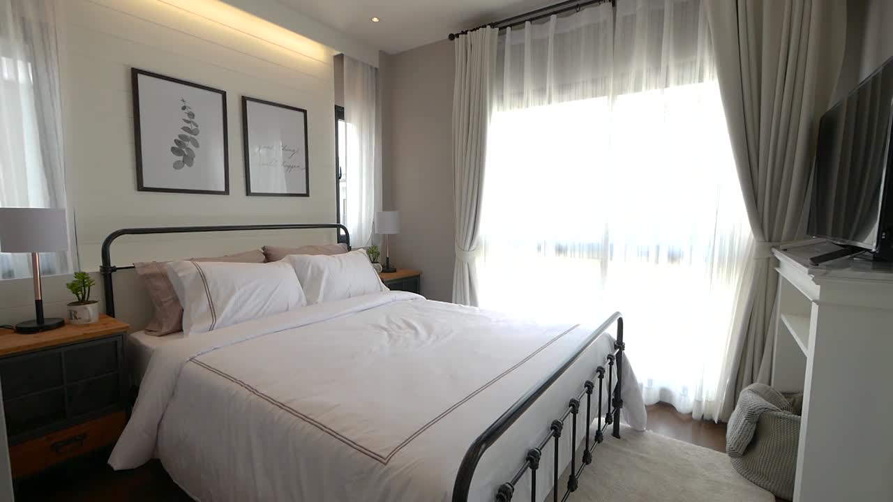 Arredamento camera da letto dai colori chiari e luminosi con mobili eleganti.