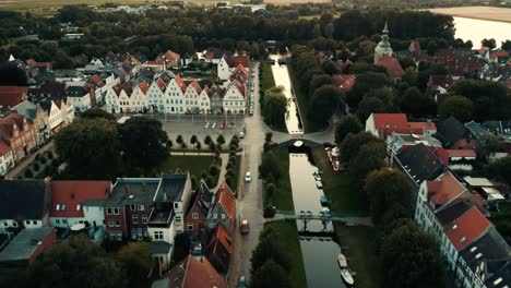 river passing through small german town with lush green trees and colorful houses