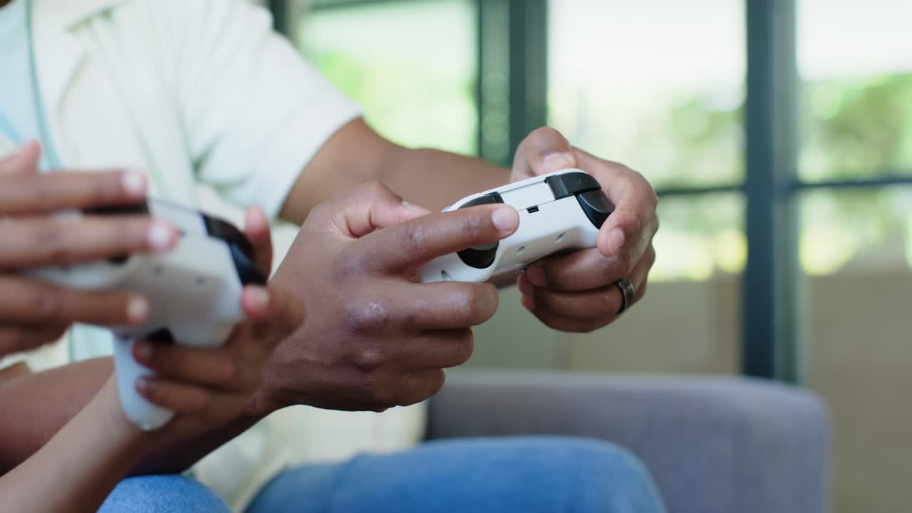 Mani di un adulto e di un bambino sul divano utilizzano controller bianchi mentre un gioco inizia, guidando la partita.
