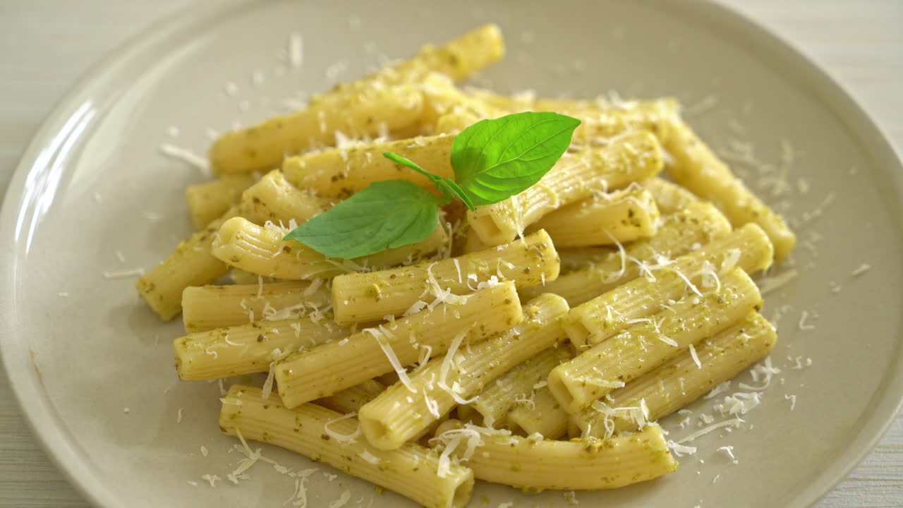 pasta al pesto rigatoni con queso parmesano - comida italiana y comida vegetariana