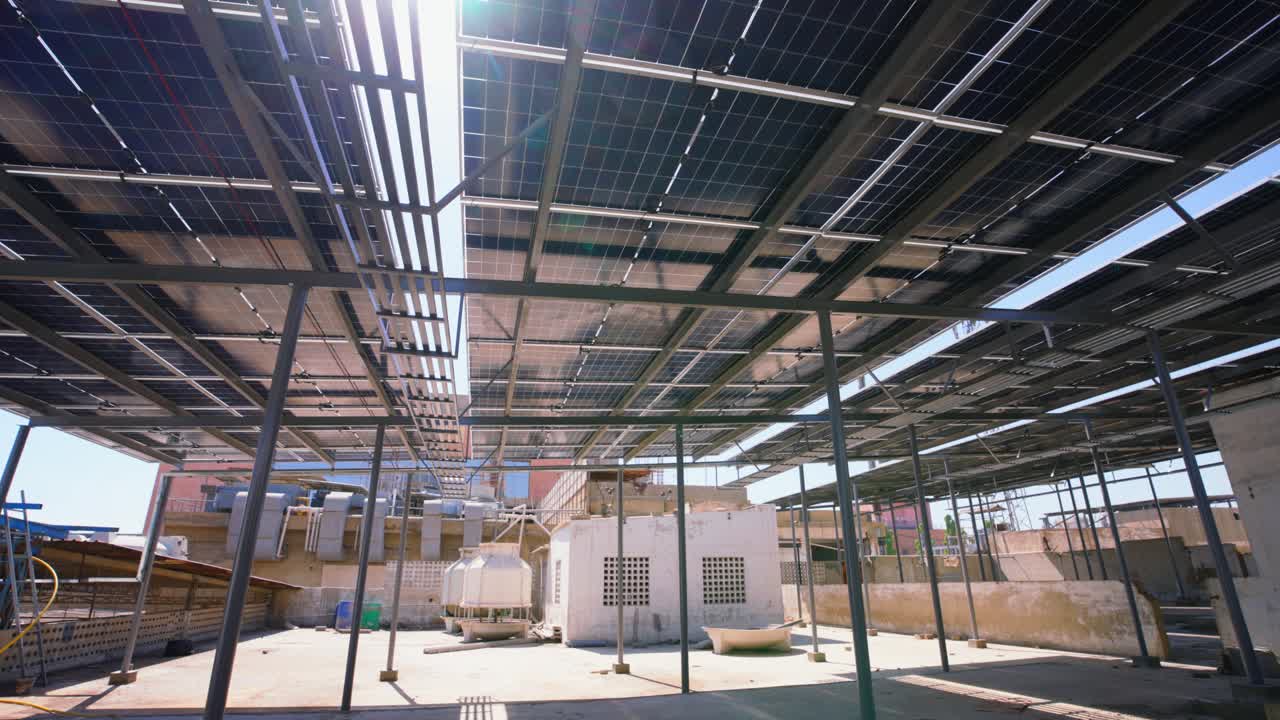 Parte inferiore dei pannelli solari sul tetto con struttura metallica sopra l'attrezzatura HVAC, che mostra l'infrastruttura urbana di energia rinnovabile.