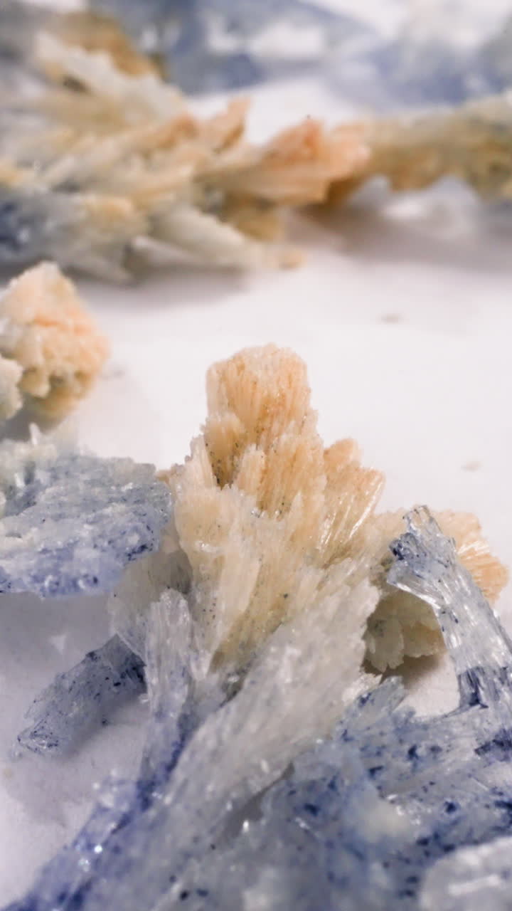 Brown and purple salt crystals scattered on white surface macro view. Natural minerals in scientific lab. Healthcare and cosmetic products ingredient