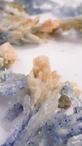 brown and purple salt crystals scattered on white surface macro view. natural minerals in scientific lab. healthcare and cosmetic products ingredient
