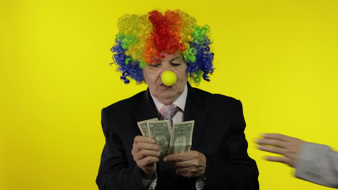 Clown female businesswoman freelancer in wig holds money income and loses it