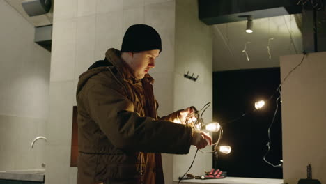 man decorating with christmas lights at home