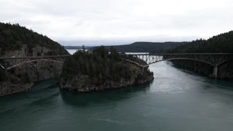 Slowly-orbiting,-revealing-dark-waters-surrounding-Deception-Pass-Bridge,-aerial