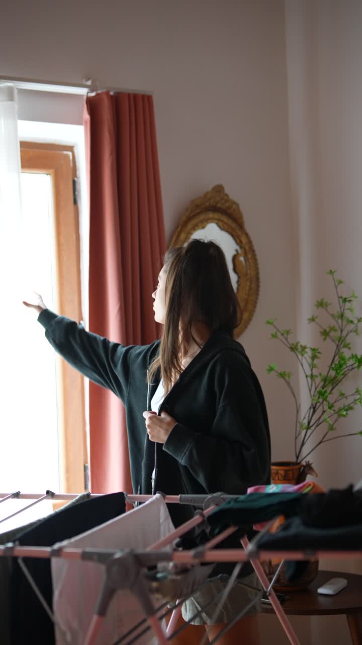 Woman Drying Clothes Indoors