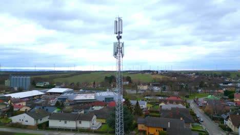 telecom tower overlooking countryside houses and farm landscape in daytime