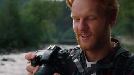 excursionista con una cámara fotográfica en las manos. fotógrafo mirando imágenes en la cámara