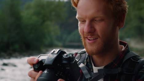 hiker holding photo camera in hands. photographer looking pictures on camera