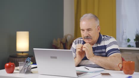 Home-office-worker-old-man-nervously-waiting-at-laptop.