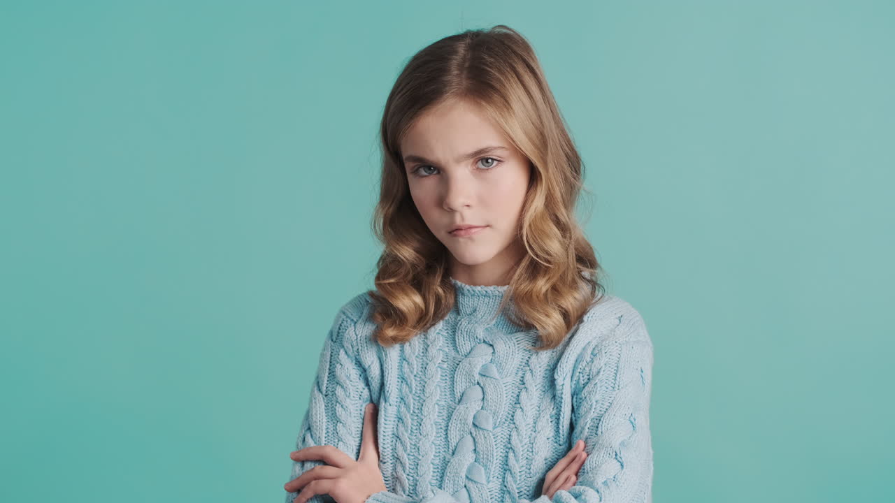 Teenage Caucasian girl crossing her arms in front of the camera.