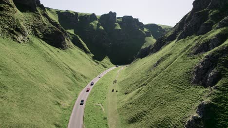 Aerial-View-Of-Vehicles-Driving-Through-Winnats-Pass-On-A-Sunny-Summer-Day-In-Peak-District,-England,-United-Kingdom