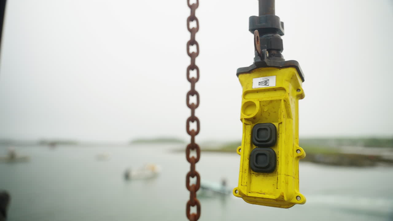 ascensor mecánico de pescador balanceándose en el viento en el puerto deportivo de nueva inglaterra y cadena colgando en el fondo 4k 60p