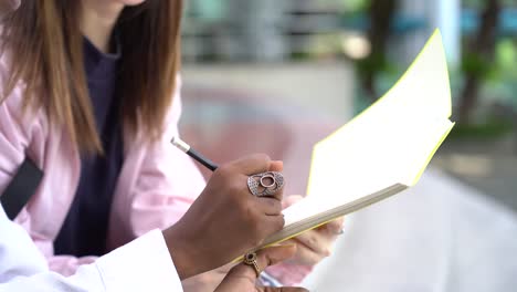 African-American-celebrity-autographing-a-notebook-for-a-fan,-unrecognizable-writing-things-for-another-one