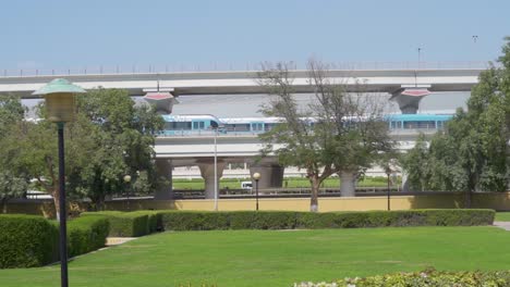 Dubai-Metro-RTA-Trains-On-The-Railway-Spanning-Across-Al-Rashidiya-Park-In-Dubai,-United-Arab-Emirates-At-Daytime