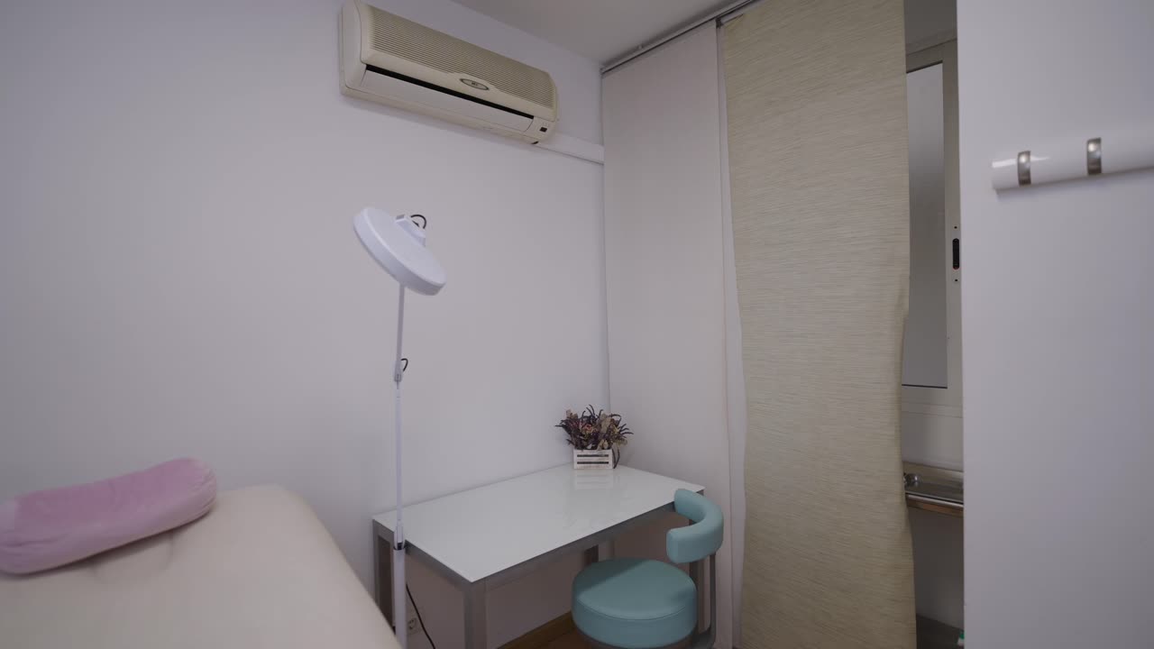 Clean and empty treatment room with examination bed and medical equipment