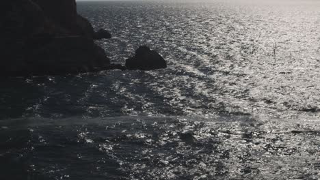 rocky coastline with dark water and reflections