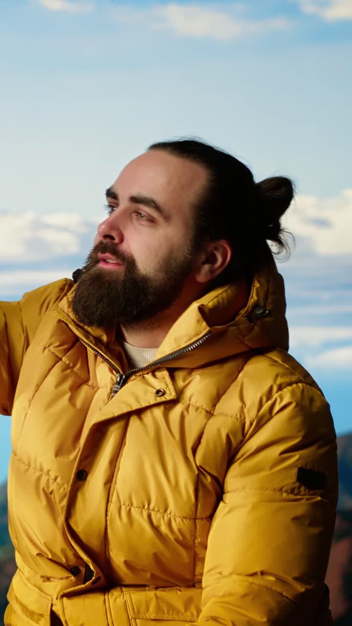 Man in Yellow Jacket Taking Selfie with Smartphone in Mountains