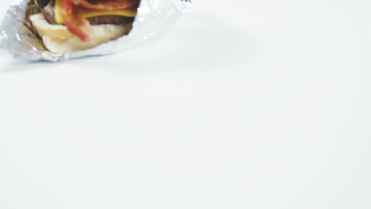 Badges animating from offscreen to foil-wrapped burger left clustering spreading showing engagement