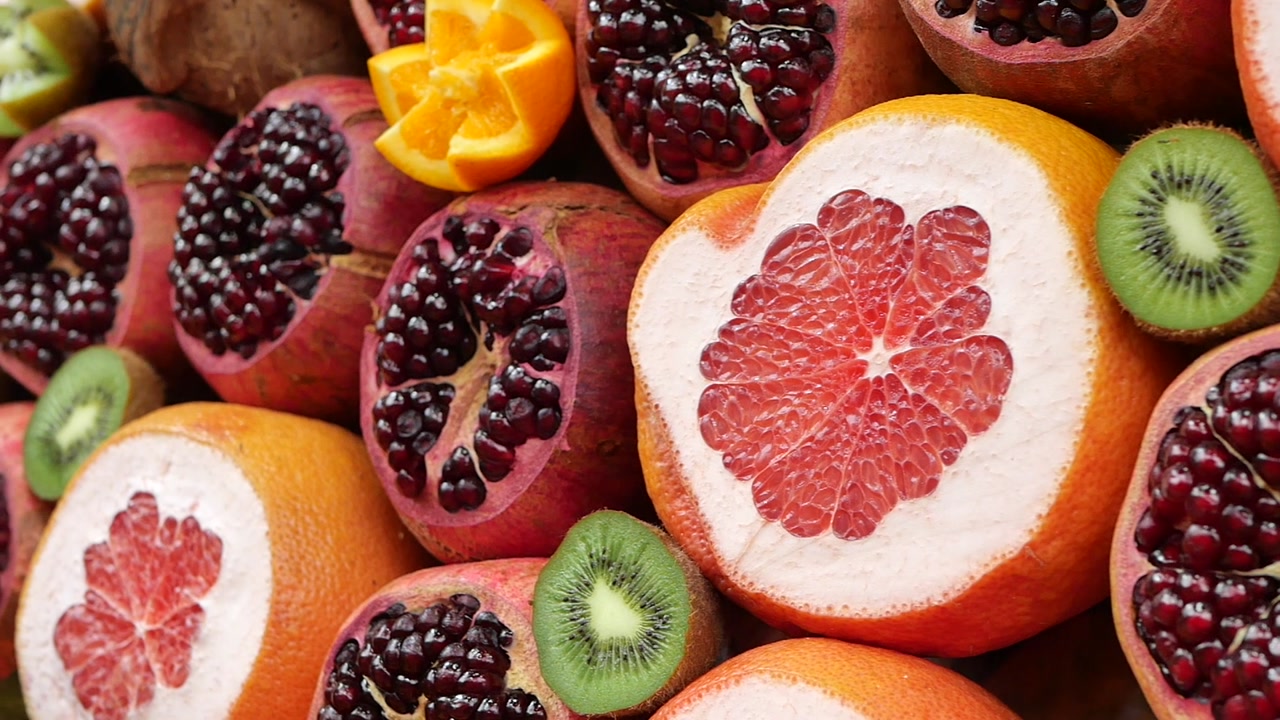 Vibrant Display of Freshly Sliced Pomegranates, Grapefruits, and Kiwis