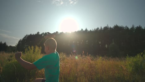 young boy flying an airplane in the country