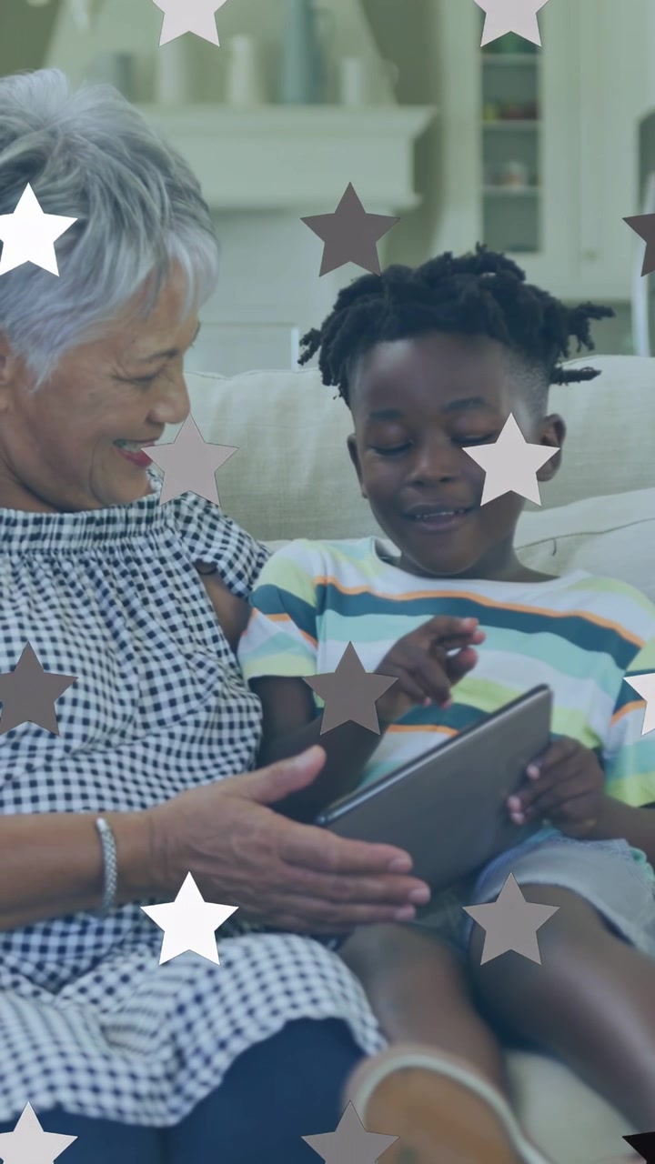 Vertical video: Grandma steadying tablet while grandson tapping, causing star overlay for education
