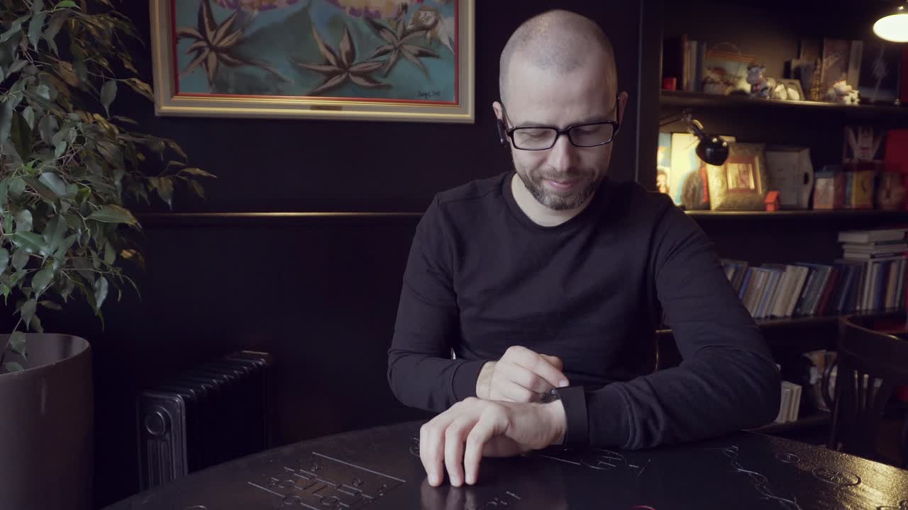 Man Checking Wrist Watch in a Cafe