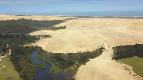 aerial ascent over the giant sand dunes and lake ngakeketa in new zealand