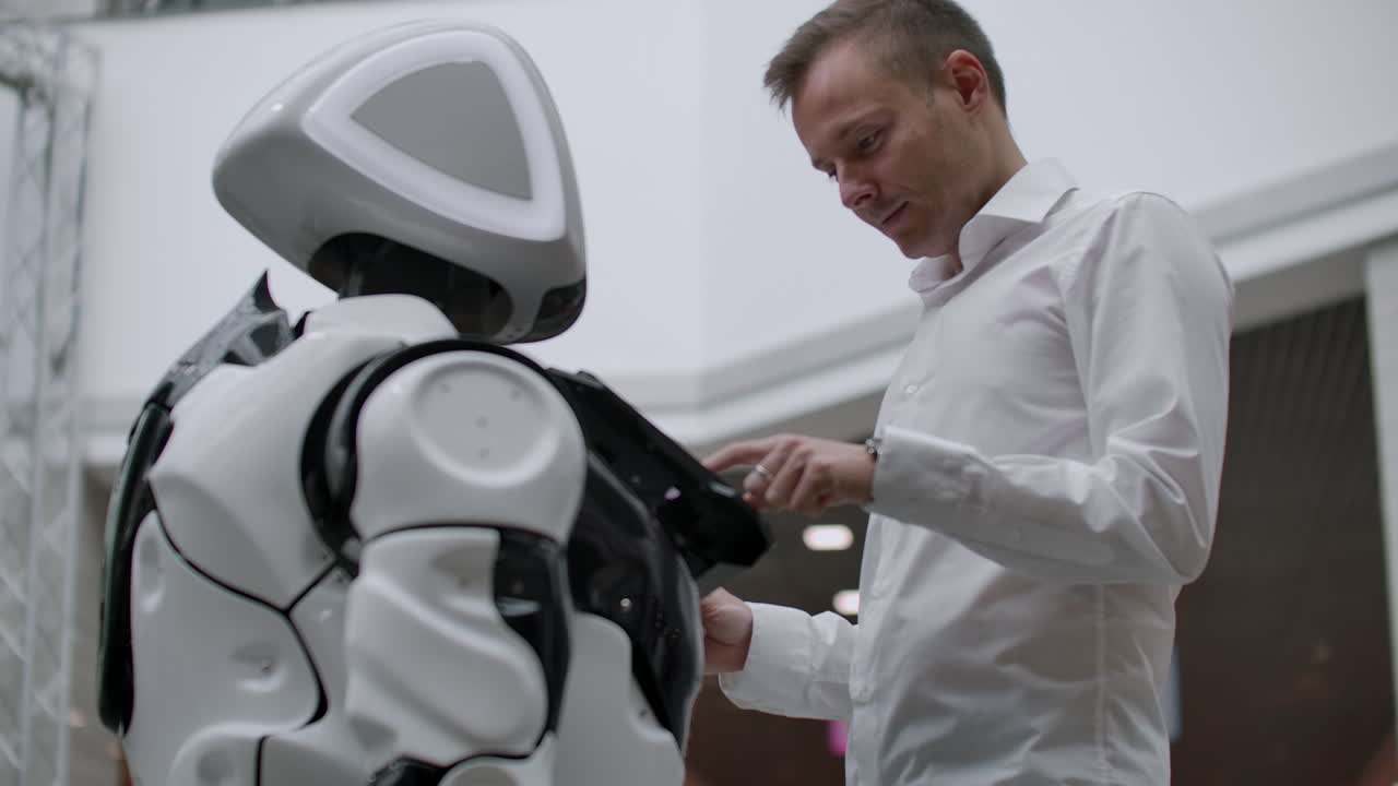 el hombre en el centro comercial se comunica con un asesor robot. tienda moderna y vendedor robot. robot ayuda a un hombre en el centro comercial.