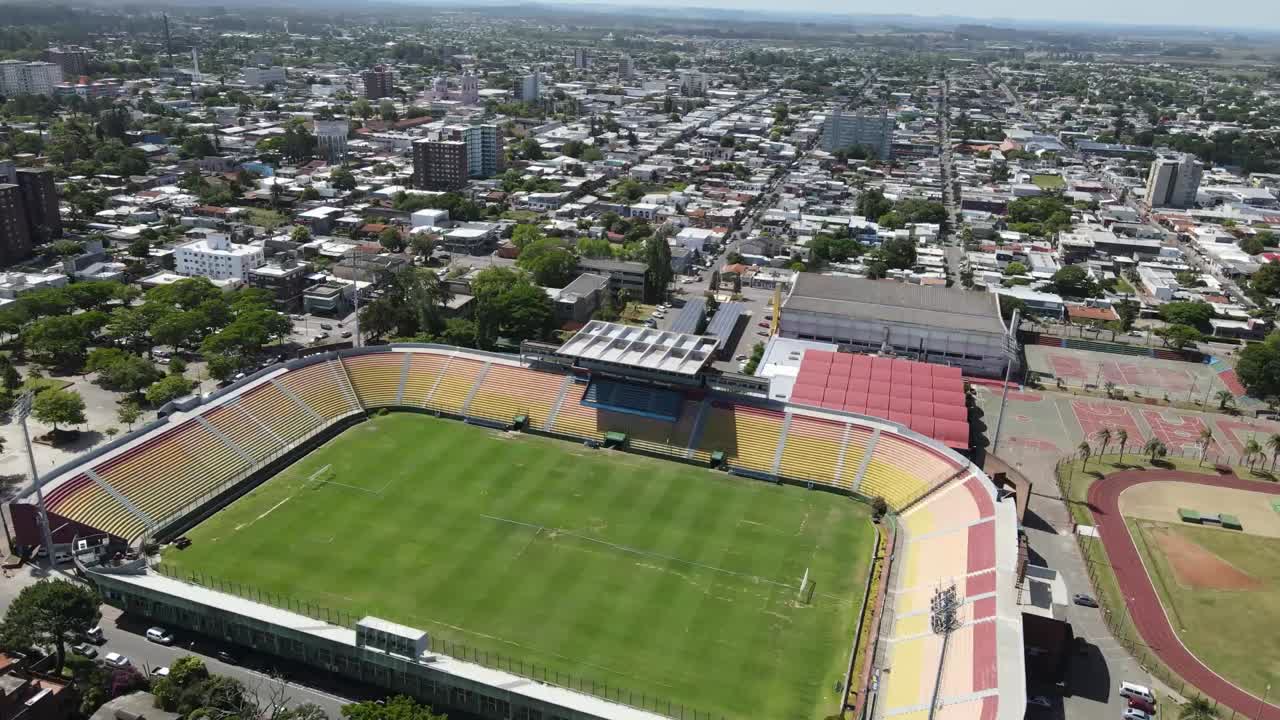 Multiple aerial perspectives reveal a soccer stadium's design, field, stands, and surrounding urban environment