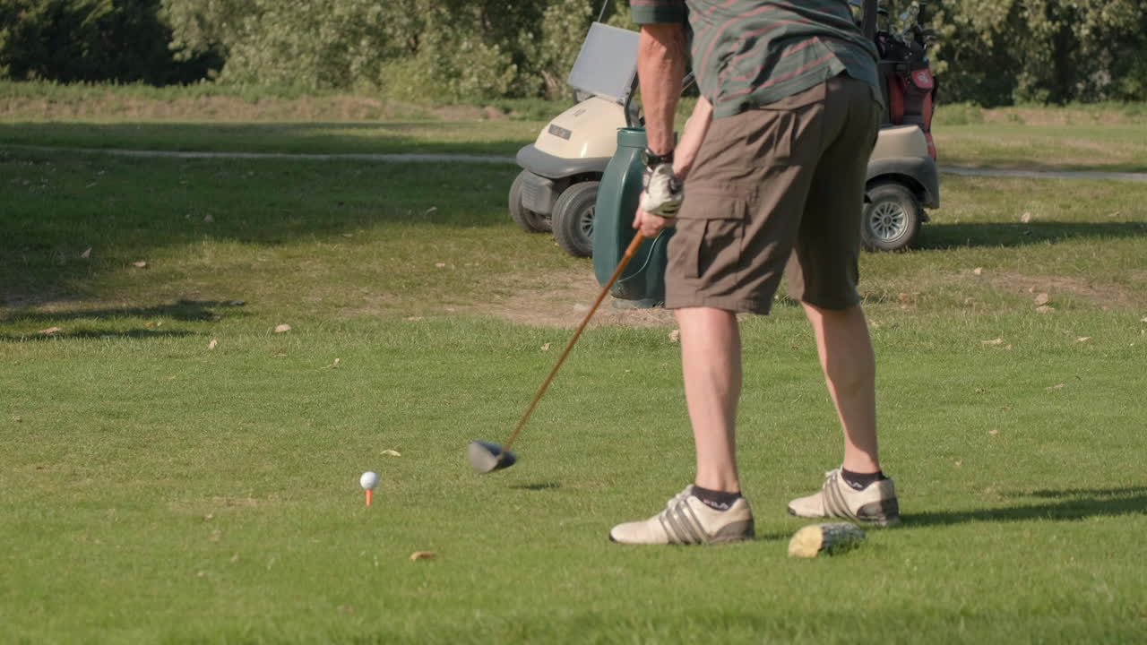 Non-professional golf player starting a new hole and making the tee fly